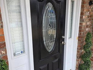 Black front door with brick exterior by MAXXPRO